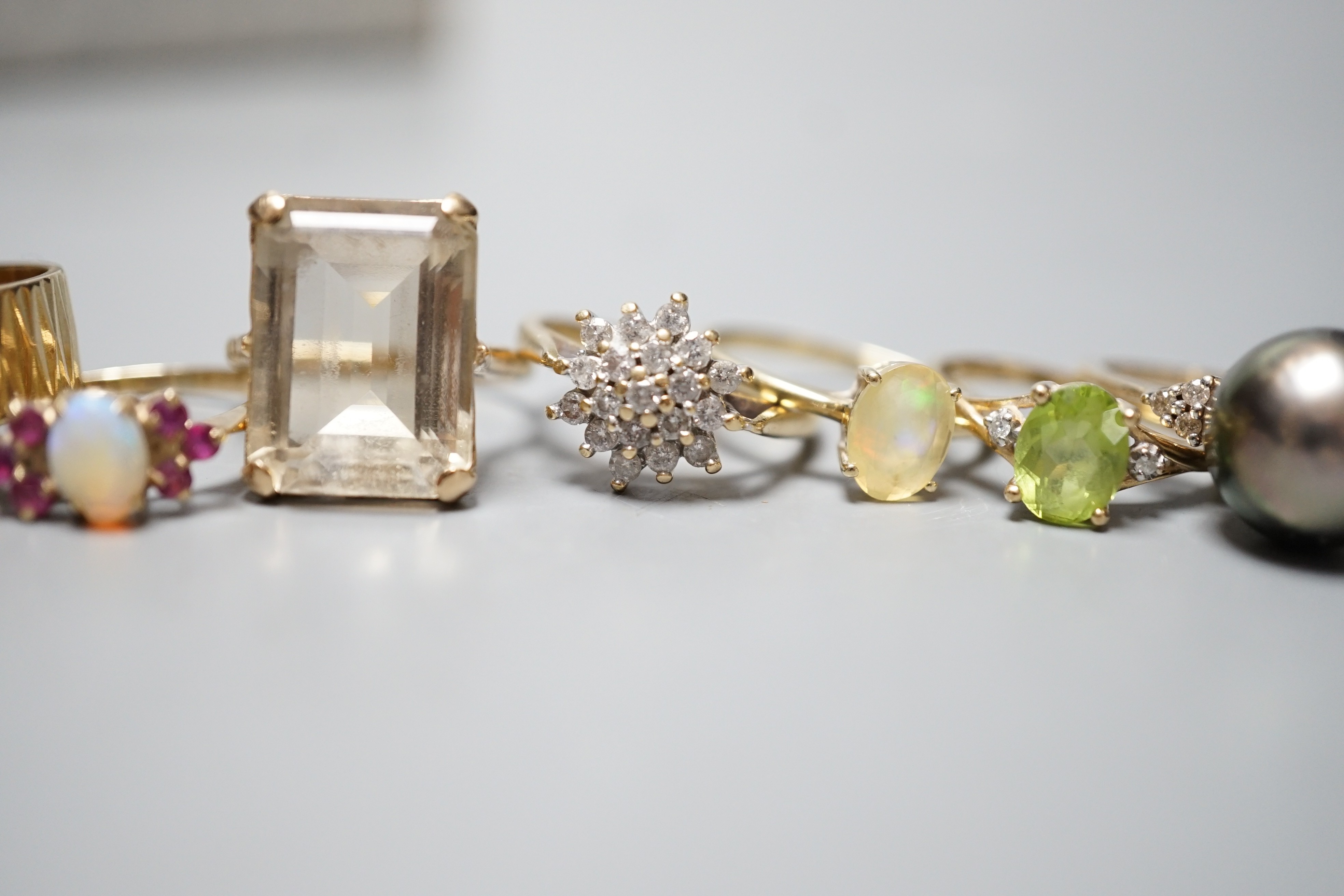 Seven assorted modern 9ct gold and gem set dress rings, including diamond cluster, white opal and white opal and ruby cluster, one stamped 9ct only.